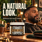 Man with a full beard in a barber's chair next to Samson's Beard Balm: a natural look without too much shine