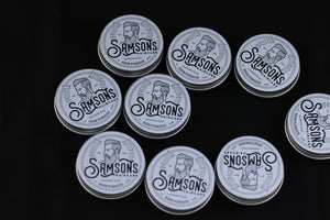 Angled overhead view of 1 oz hair pomades with the old logo spread out.